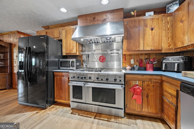 2296 Athens Rd, Royston, GA 30662 - kitchen with stainless steel appliances, extractor fan, brown cabinets, light wood-style floors, and a textured ceiling