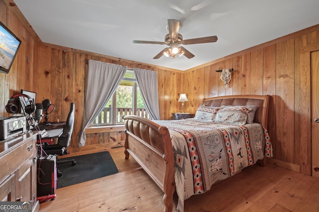 2296 Athens Rd, Royston, GA 30662 - bedroom featuring wood walls, light wood-style floors, and a ceiling fan