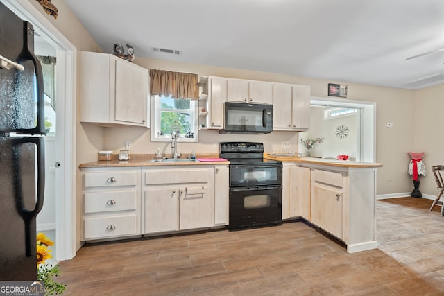 2296 Athens Rd, Royston, GA 30662 - kitchen with black appliances, a peninsula, light countertops, and light wood-style flooring