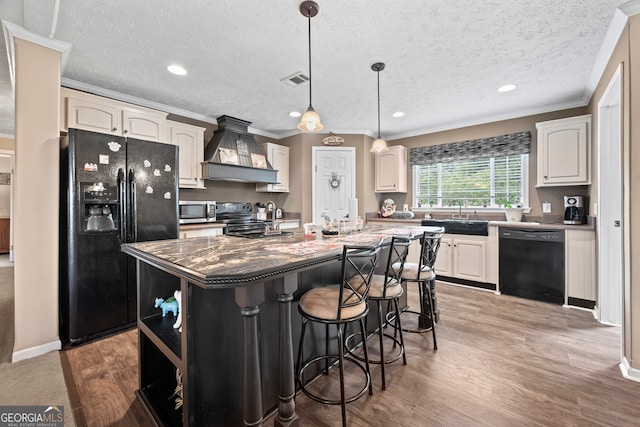 2296 Athens Rd, Royston, GA 30662 - kitchen with black appliances, premium range hood, ornamental molding, a kitchen island with sink, and a textured ceiling