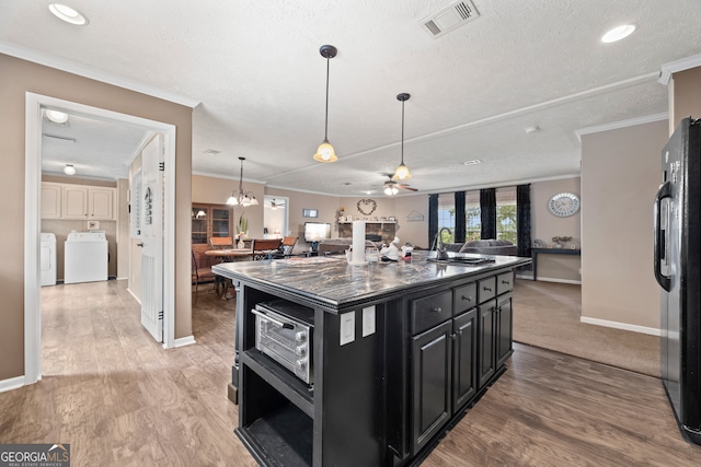 2296 Athens Rd, Royston, GA 30662 - kitchen featuring dark cabinets, washing machine and clothes dryer, open floor plan, freestanding refrigerator, and dark countertops