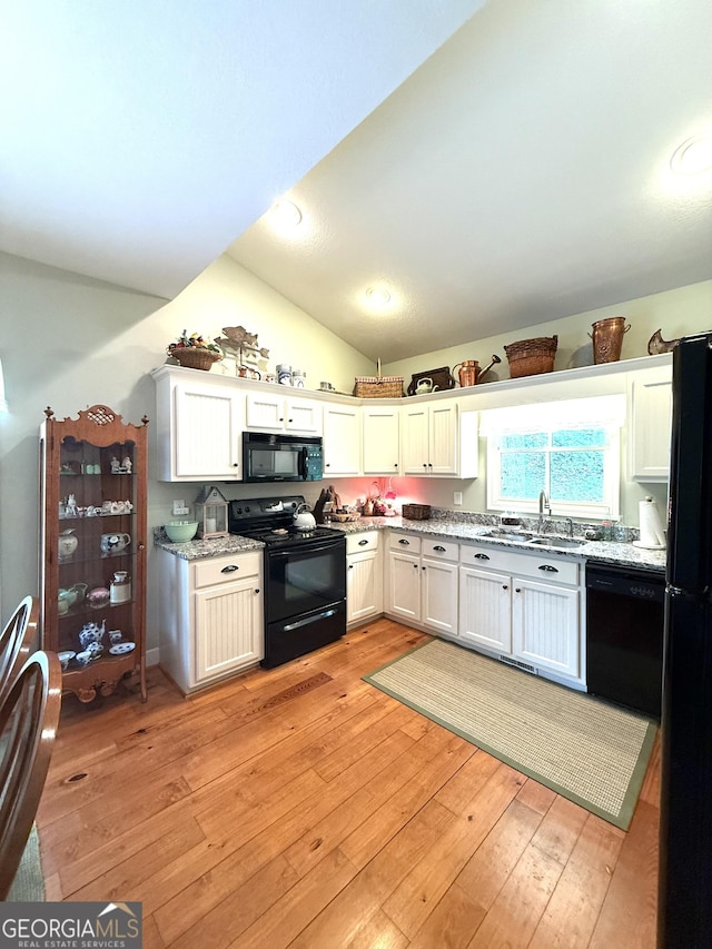 105 Evergreen Rd, Hiawassee, GA 30546 - kitchen featuring black appliances, lofted ceiling, light wood finished floors, light stone countertops, and white cabinets