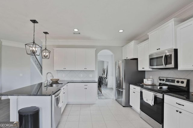358 Brookhaven Loop NE, Ludowici, GA 31316 - kitchen featuring appliances with stainless steel finishes, a peninsula, arched walkways, white cabinetry, and crown molding