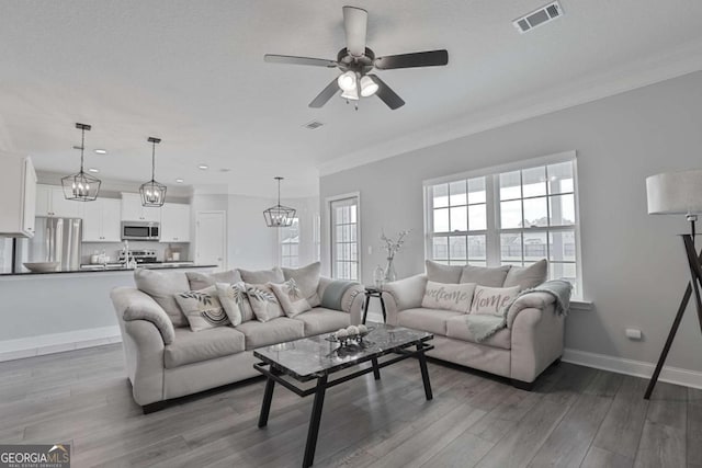 358 Brookhaven Loop NE, Ludowici, GA 31316 - living area with wood finished floors, a ceiling fan, recessed lighting, crown molding, and a chandelier