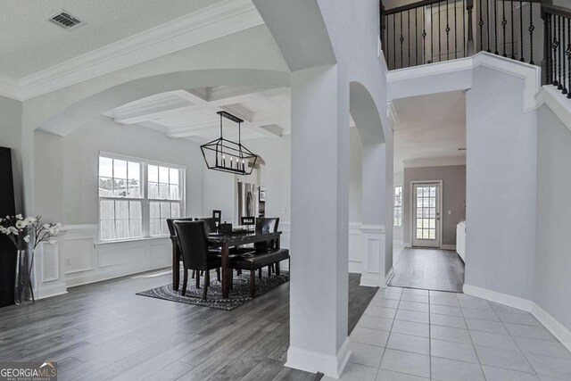 358 Brookhaven Loop NE, Ludowici, GA 31316 - dining area with arched walkways, light wood-style floors, beam ceiling, a wainscoted wall, and crown molding