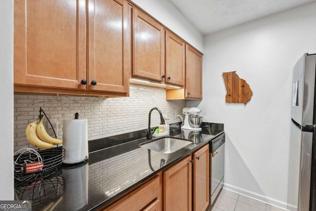 3115 Seven Pines Ct Unit 308, Atlanta, GA 30339 - kitchen featuring stainless steel appliances, dark stone counters, backsplash, light tile patterned flooring, and brown cabinetry