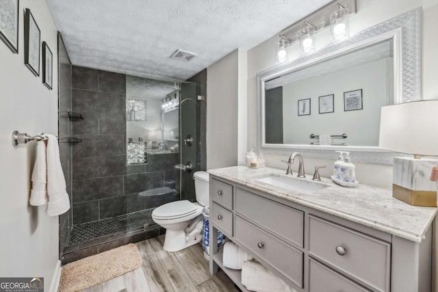 3115 Seven Pines Ct Unit 308, Atlanta, GA 30339 - bathroom with vanity, wood finished floors, a shower stall, and a textured ceiling
