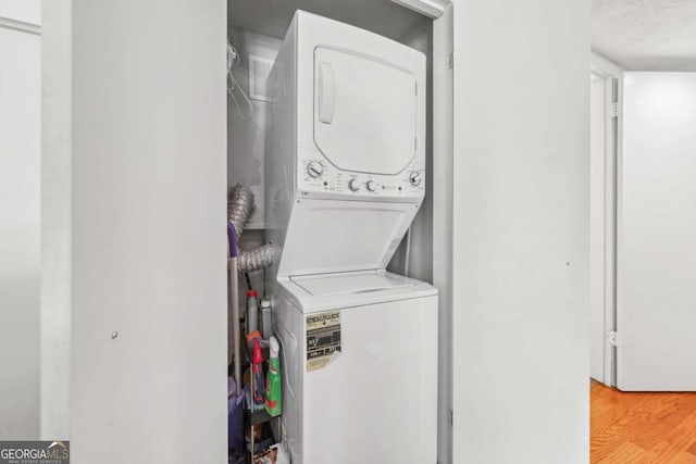 3115 Seven Pines Ct Unit 308, Atlanta, GA 30339 - washroom with stacked washer / dryer and light wood finished floors