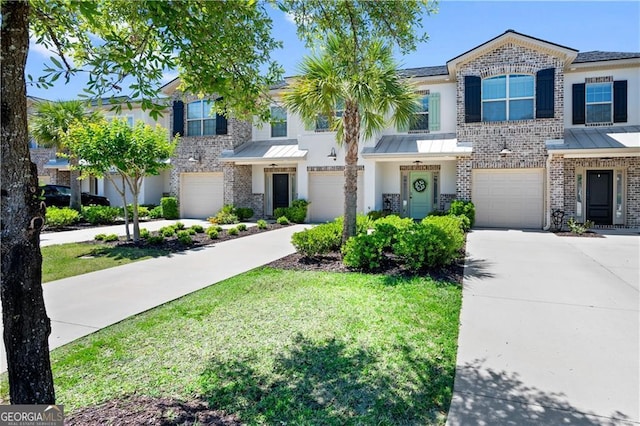 509 Mariners Cir, Saint Simons, GA 31522 - townhome / multi-family property with driveway, brick siding, an attached garage, and a standing seam roof