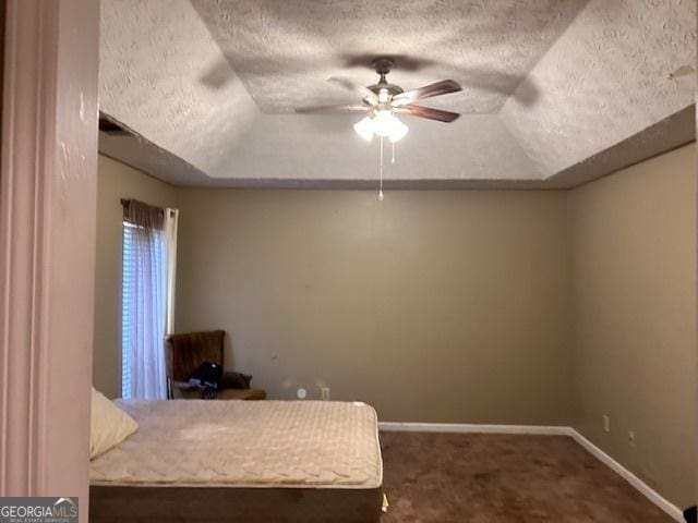 8519 Glenwoods Dr, Riverdale, GA 30274 - carpeted bedroom with a textured ceiling, a tray ceiling, vaulted ceiling, and a ceiling fan