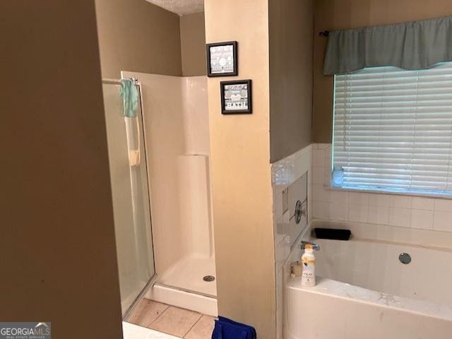 8519 Glenwoods Dr, Riverdale, GA 30274 - full bathroom with tile patterned floors, a garden tub, and a shower stall