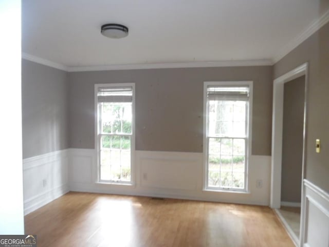 1205 Pebble Bend Dr, Grayson, GA 30017 - spare room featuring ornamental molding, wainscoting, and light wood-type flooring