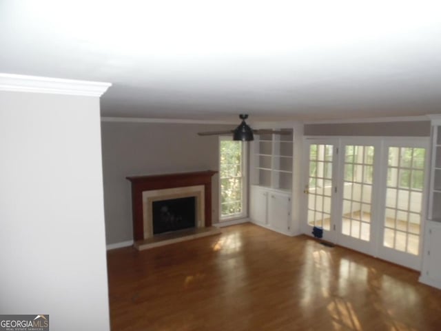 1205 Pebble Bend Dr, Grayson, GA 30017 - unfurnished living room with crown molding, a fireplace with raised hearth, and wood finished floors