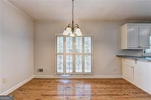 2324 Blackberry Ct, Snellville, GA 30078 - unfurnished dining area with plenty of natural light, wood finished floors, and a chandelier