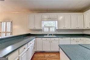 2324 Blackberry Ct, Snellville, GA 30078 - kitchen with white cabinetry, plenty of natural light, dark countertops, and light wood finished floors