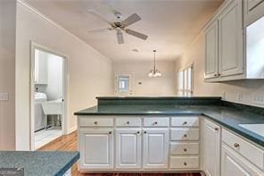 2324 Blackberry Ct, Snellville, GA 30078 - kitchen with a peninsula, dark countertops, ceiling fan, wood finished floors, and decorative light fixtures