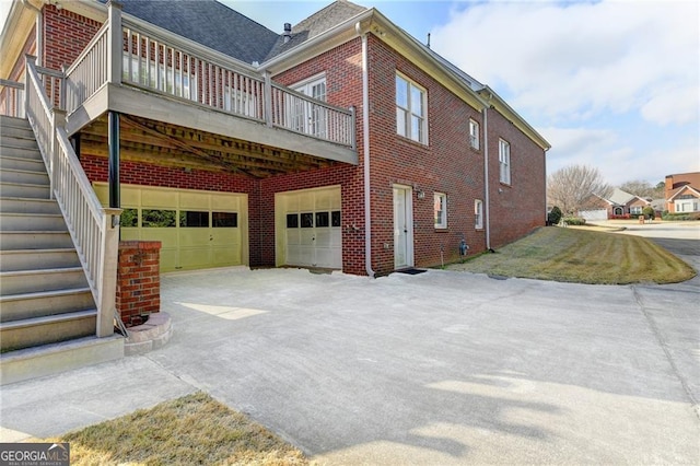 2324 Blackberry Ct, Snellville, GA 30078 - view of home's exterior featuring a garage, brick siding, concrete driveway, a wooden deck, and stairs