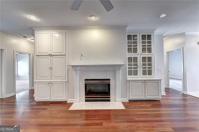 2324 Blackberry Ct, Snellville, GA 30078 - unfurnished living room with ornamental molding, wood finished floors, a ceiling fan, a tiled fireplace, and recessed lighting