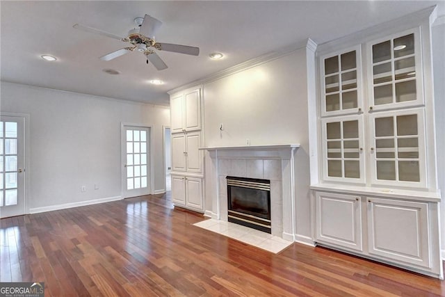 2324 Blackberry Ct, Snellville, GA 30078 - unfurnished living room featuring ornamental molding, plenty of natural light, a fireplace, wood finished floors, and a ceiling fan
