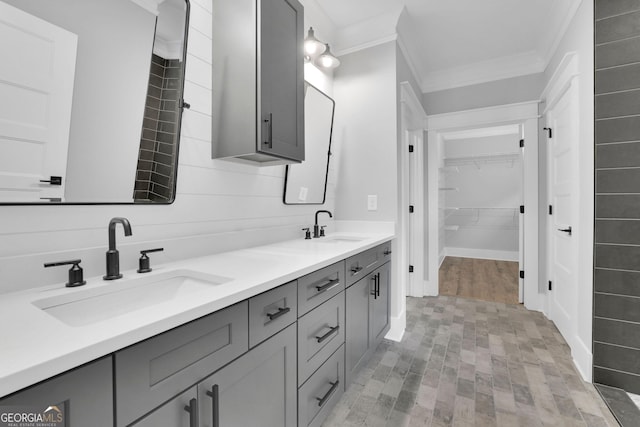 153 Alaina Rd, Holly Springs, GA 30115 - bathroom featuring crown molding, double vanity, brick patterned floors, and a walk in closet