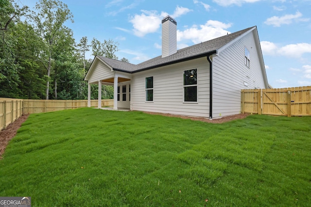153 Alaina Rd, Holly Springs, GA 30115 - rear view of house featuring a fenced backyard, a chimney, and a shingled roof