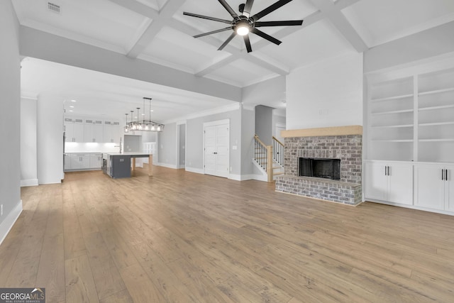 153 Alaina Rd, Holly Springs, GA 30115 - unfurnished living room featuring a fireplace, a ceiling fan, light wood-style flooring, coffered ceiling, and beamed ceiling