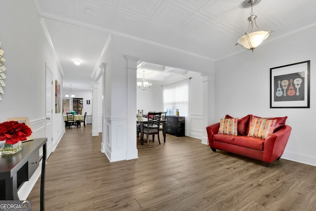 425 Eldridge Dr, Suwanee, GA 30024 - living room featuring a chandelier, ornate columns, wood finished floors, crown molding, and a decorative wall