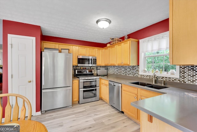 52 Cherub Ln, Sharpsburg, GA 30277 - kitchen with appliances with stainless steel finishes, light brown cabinetry, tasteful backsplash, light wood-style floors, and a textured ceiling