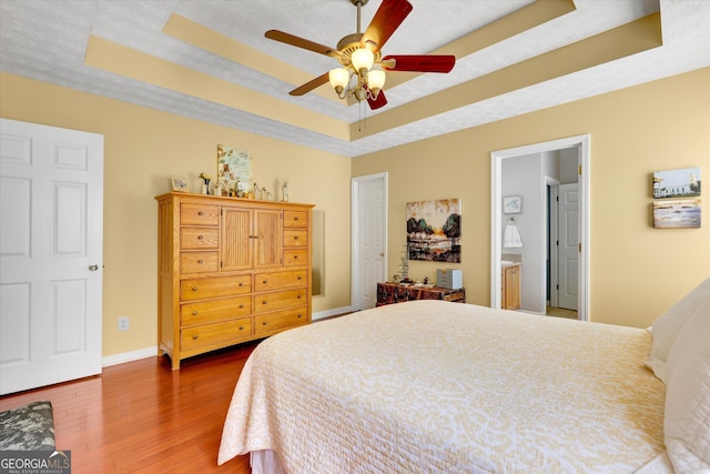 52 Cherub Ln, Sharpsburg, GA 30277 - bedroom with a raised ceiling, wood finished floors, ceiling fan, and connected bathroom
