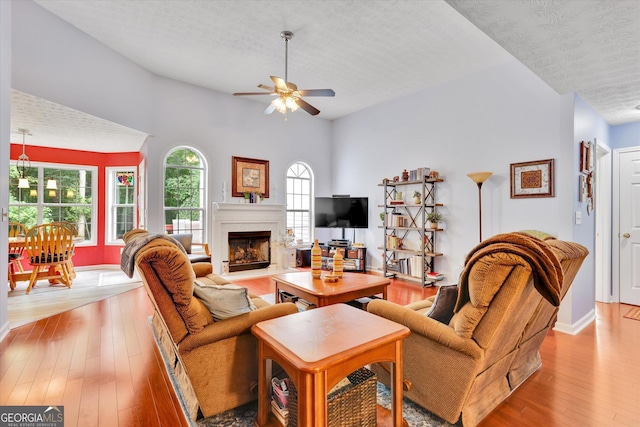 52 Cherub Ln, Sharpsburg, GA 30277 - living room featuring ceiling fan, a textured ceiling, light wood finished floors, and a fireplace