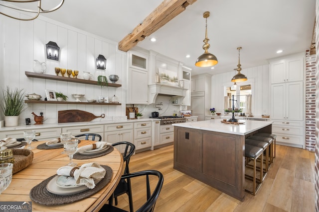 639 Frank Crook Rd, Canon, GA 30520 - kitchen with light countertops, light wood-style floors, a kitchen island, glass insert cabinets, and white cabinetry