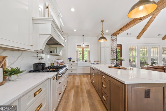 639 Frank Crook Rd, Canon, GA 30520 - kitchen with stainless steel gas stovetop, white cabinetry, light wood finished floors, a spacious island, and backsplash