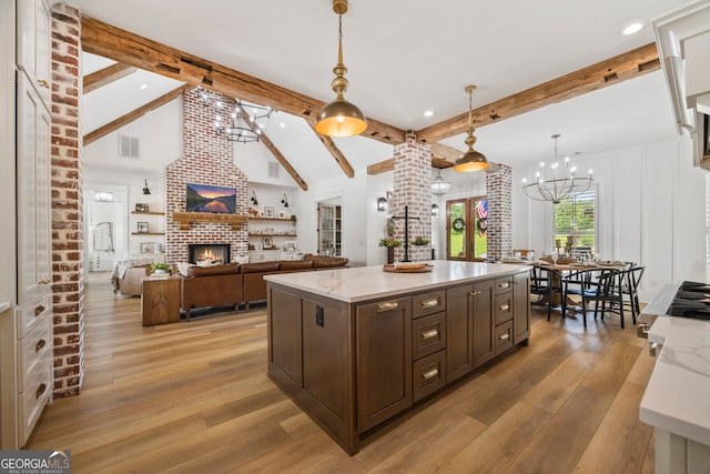 639 Frank Crook Rd, Canon, GA 30520 - kitchen with a brick fireplace, a chandelier, light wood-style flooring, dark brown cabinetry, and pendant lighting