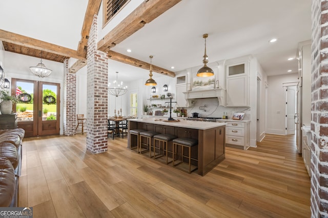 639 Frank Crook Rd, Canon, GA 30520 - kitchen featuring a chandelier, light countertops, white cabinets, a kitchen breakfast bar, and light wood finished floors