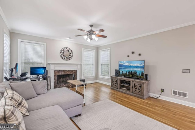 3887 Hickory Manor Dr, Suwanee, GA 30024 - living room with crown molding, healthy amount of natural light, a ceiling fan, wood finished floors, and a high end fireplace
