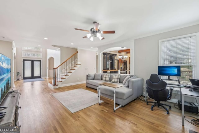 3887 Hickory Manor Dr, Suwanee, GA 30024 - living room featuring arched walkways, stairway, french doors, a ceiling fan, and light wood-style floors