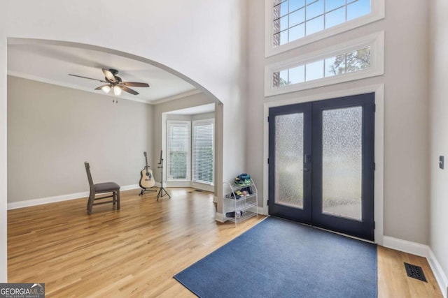 3887 Hickory Manor Dr, Suwanee, GA 30024 - entrance foyer with arched walkways, wood finished floors, ornamental molding, ceiling fan, and french doors
