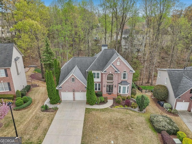3887 Hickory Manor Dr, Suwanee, GA 30024 - view of front of home with driveway, brick siding, a chimney, and a front yard