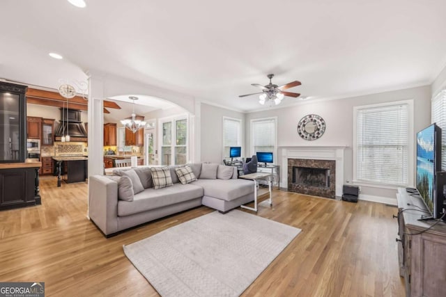 3887 Hickory Manor Dr, Suwanee, GA 30024 - living area featuring ceiling fan, a fireplace, light wood finished floors, crown molding, and a chandelier