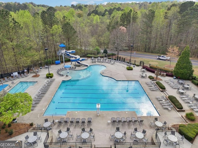 3887 Hickory Manor Dr, Suwanee, GA 30024 - community pool with a water slide, a wooded view, and a patio
