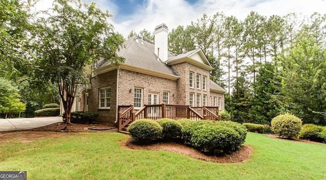35 Inverleigh Row, Covington, GA 30014 - back of property featuring a yard, a wooden deck, brick siding, and a chimney