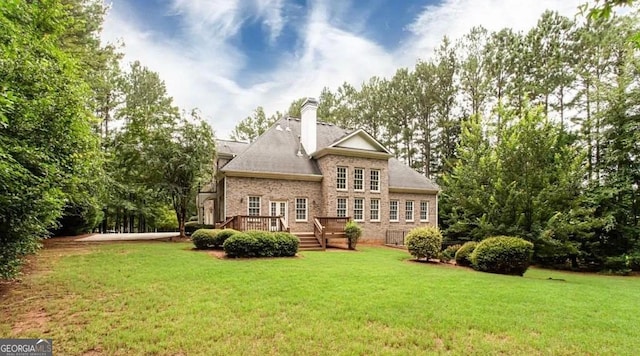 35 Inverleigh Row, Covington, GA 30014 - rear view of property with a yard, a deck, brick siding, and a chimney