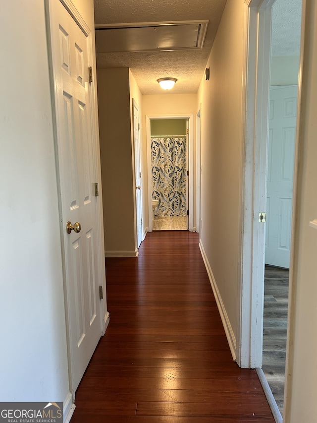 375 Sapphire Bnd, Riverdale, GA 30296 - hallway with dark wood-type flooring, a textured ceiling, and attic access