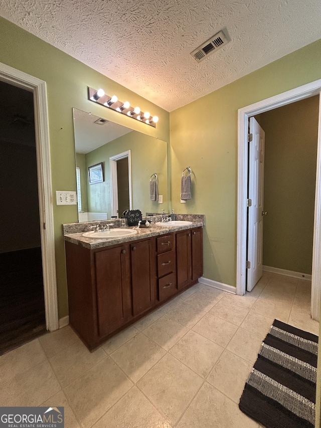 375 Sapphire Bnd, Riverdale, GA 30296 - full bath featuring double vanity, tile patterned floors, and a textured ceiling