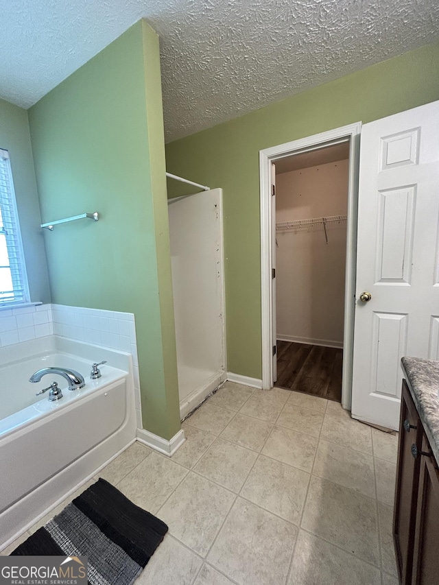 375 Sapphire Bnd, Riverdale, GA 30296 - full bathroom featuring a stall shower, a bath, tile patterned floors, vanity, and a textured ceiling