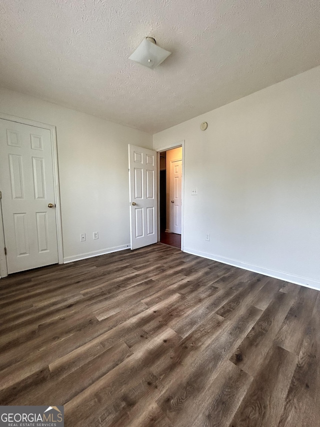 375 Sapphire Bnd, Riverdale, GA 30296 - unfurnished bedroom featuring dark wood finished floors and a textured ceiling
