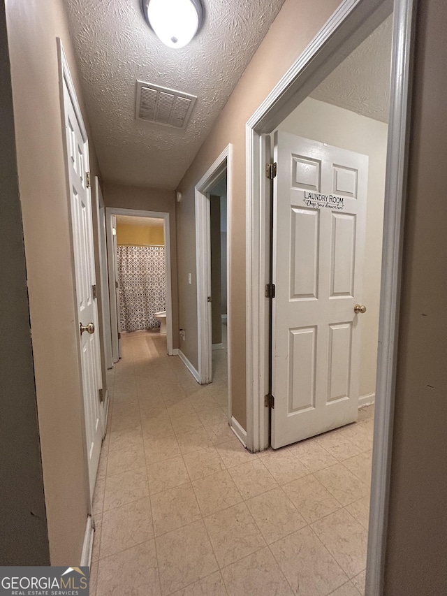 375 Sapphire Bnd, Riverdale, GA 30296 - hall with a textured ceiling and light tile patterned floors