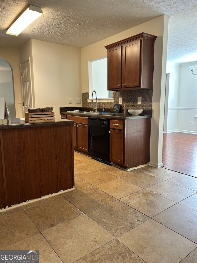 375 Sapphire Bnd, Riverdale, GA 30296 - kitchen with black dishwasher, dark countertops, tasteful backsplash, arched walkways, and a textured ceiling