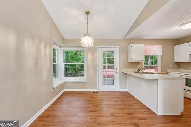 3450 Saddleton Way, Douglasville, GA 30134 - kitchen featuring light wood-style floors, light countertops, white cabinets, plenty of natural light, and lofted ceiling