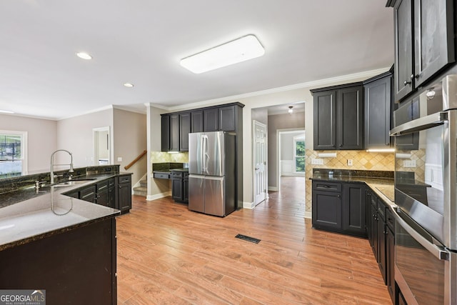 4685 Braselton Hwy, Hoschton, GA 30548 - kitchen featuring appliances with stainless steel finishes, dark stone counters, ornamental molding, tasteful backsplash, and recessed lighting